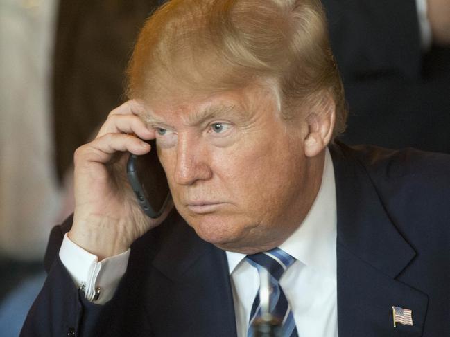 FILE - In this Feb. 18, 2016 file photo, Republican presidential candidate Donald Trump listens to his mobile phone during a lunch stop in North Charleston, S.C. Trump’s approach to Twitter has been as unorthodox as his presidential campaign. The billionaire’s use of the social media service has been unpredictable and unfiltered, sometimes brilliant and occasionally typographically challenged. He has celebrated the support of scores of accounts that appear almost solely dedicated to him. (AP Photo/Matt Rourke, File)