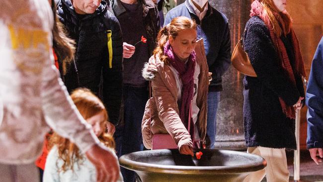 People lay poppies in the Shrine’s sanctuary during Anzac Day commemorations. Picture: Aaron Francis