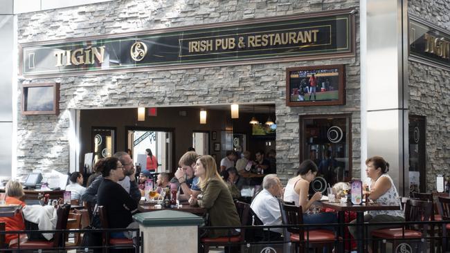 People dining at Tigin Irish Pub &amp; Restaurant in the terminal of Dallas International Airport, Texas, USA.