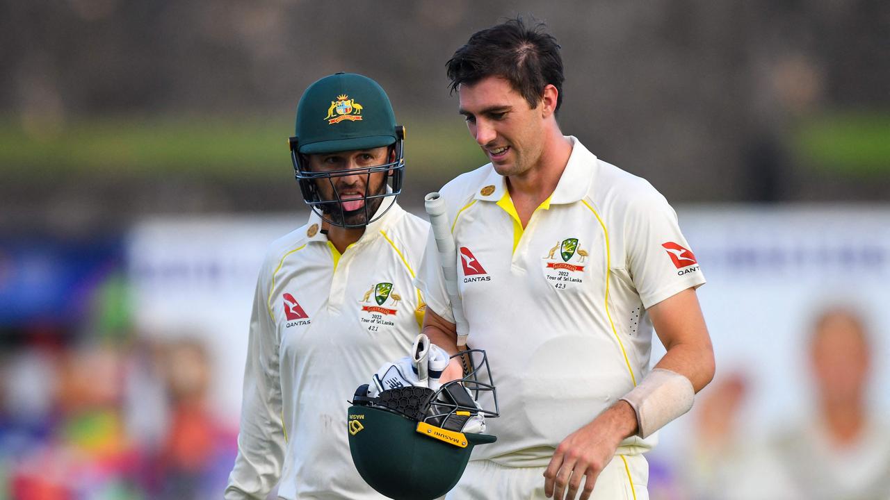 Australia's Nathan Lyon (R) and captain Pat Cummins walk back to the pavilion at the end of the second day play of the first cricket Test match between Sri Lanka and Australia at the Galle International Cricket Stadium in Galle on June 30, 2022. (Photo by ISHARA S. KODIKARA / AFP)