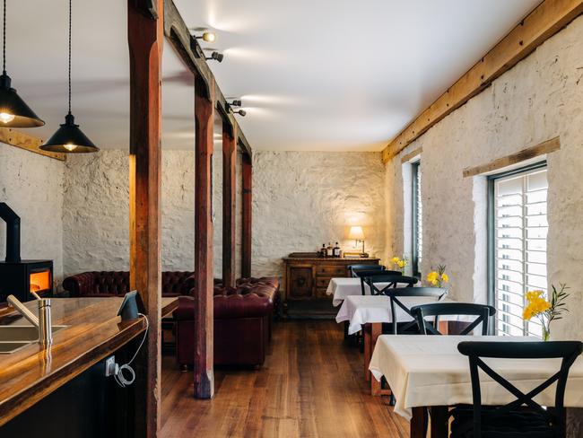 Triabunna Barracks’ kitchen, dining and cosy lounge which features the original hitching posts horses were tied to in the building’s former life as a stables. Picture: Adam Gibson