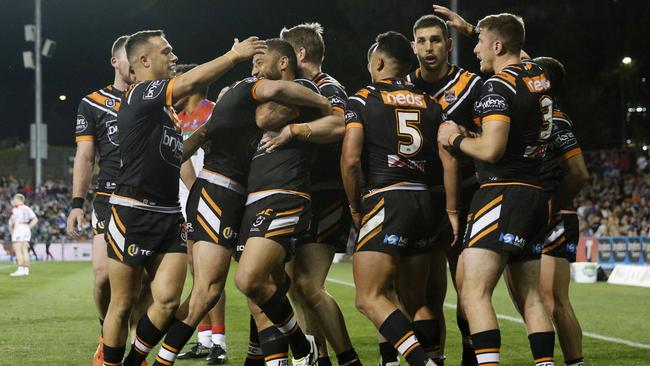 Tigers players celebrate one of David Nofoaluma’s tries against the Knights.