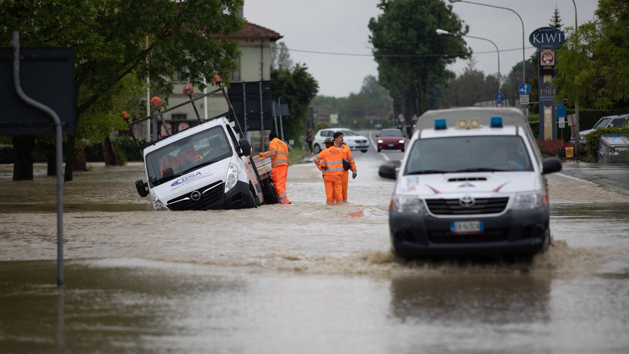 Rescuers stand by a truck following floods in Castel Bolognese, near Ravenna. Photo by STRINGER / ANSA / AFP