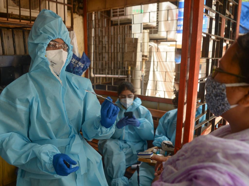 A health worker wearing PPE gear speaks to a resident while using a fingertip pulse oximeter on her during the COVID-19 coronavirus screening in Mumbai on August 27, 2020. Picture: Indranil MUKHERJEE / AFP