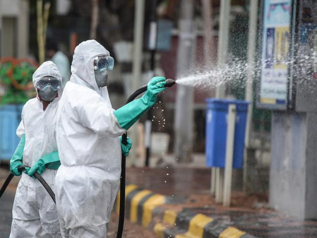 Members from the Disaster Response Force (DRF) in India spray disinfectant on a street as cases surge. Picture: AFP