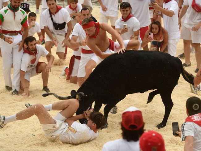 A man jumps over a cow as people watch races during the 91st Bayonne festival in southwestern France. Picture: Gaizka Iroz/AFP