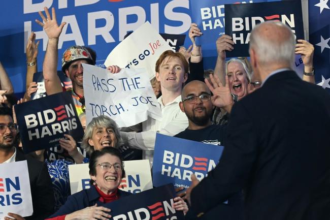 A supporter of US President Joe Biden holds a sign that read "Pass the torch Joe" during a campaign event in Madison, Wisconsin