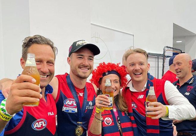 Morris Jones owner Hayden Burbank, left, in the Demons change-room after the AFL grand final. Picture: Instagram