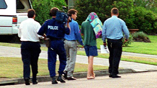 SLD, covered by a towel, being arrested as a 13-year-old in 2001 for the murder of Courtney Morley-Clarke.