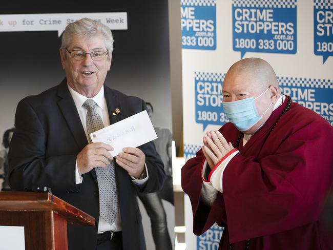 Crime Stoppers Tasmania chair David Daniels receives a donation from Chinese Buddhist Academy of Australia’s Master Wang. Picture: Chris Kidd