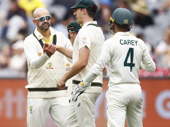 MELBOURNE, AUSTRALIA - DECEMBER 29: Nathan Lyon of Australia (C) celebrates with Pat Cummins of Australia after combining to dismiss Kagiso Rabada of South Africa during day four of the Second Test match in the series between Australia and South Africa at Melbourne Cricket Ground on December 29, 2022 in Melbourne, Australia. (Photo by Daniel Pockett/Getty Images)