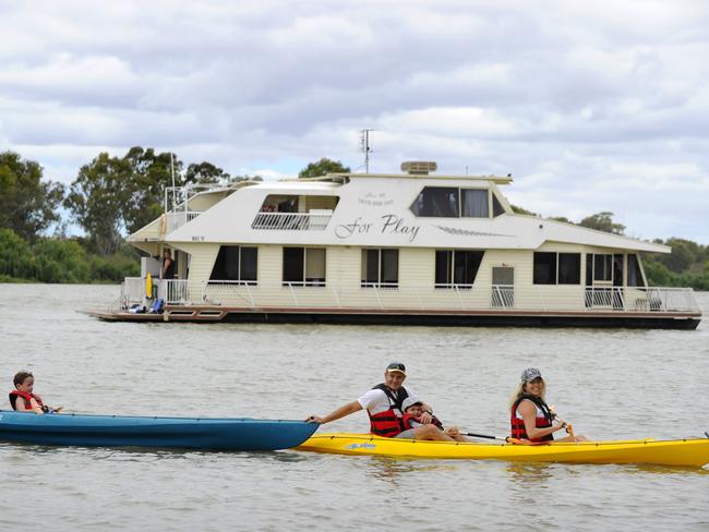 Houseboat holidays on the River Murray are popular these summer holidays due to high water levels and affordability. Regular house boaters Tony and Sarah Brdar kayaking with their son Martin, 3, and his friend Jamieson (blue boat) at Mannum.