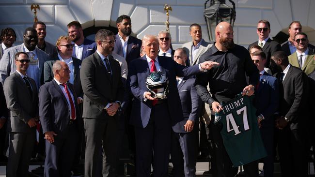 Donald Trump holds an Eagles helmet as he poses with head coach Nick Sirianni and offensive tackle Lane Johnson at the White House. Picture: Getty Images