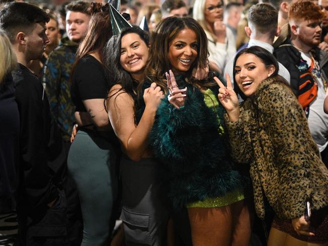 Revellers pose for a photo as they queue to enter a club in Manchester, northwest England on New Year's Eve. Picture: AFP