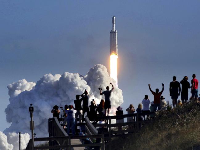 The crowd cheers at Playalinda Beach in the Canaveral National Seashore, just north of the Kennedy Space Center, during the successful launch of the SpaceX Falcon Heavy rocket, Tuesday, Feb. 6, 2018. Playalinda is one of closest public viewing spots to see the launch, about 3 miles from the SpaceX launchpad 39A. (Joe Burbank/Orlando Sentinel via AP)