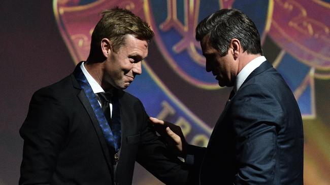 Former Hawthorn player Sam Mitchell (left) is retrospectively awarded the 2012 Brownlow Medal by Shane Crawford. Picture: AAP Image/Julian Smith