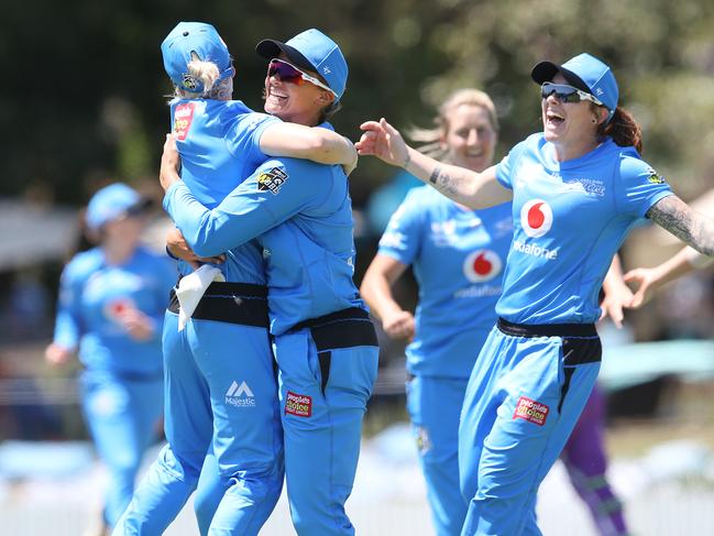 Suzie Bates (right) wraps up Katie Mack in a celebratory hug after Mack took the crucial catch to send Nicola Carey back to the stands and seal the Strikers’ three-run win over the Hobart Hurricanes in Brisbane. Picture: JONO SEARLE/GETTY IMAGES