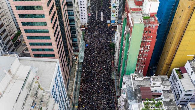 Thousands of protesters march through the street as they take part in a rally against the controversial extradition law proposal in Hong Kong.