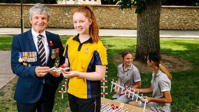 Veteran Don Corey, and St Aloysius College year 10 Emily Crocker, with year 9s Avalon Smeaton and Freja Milne planting the 2/43rd Battalion Association memorial cross at the Field of Remembrance at the National War Memorial. Picture: Morgan Sette