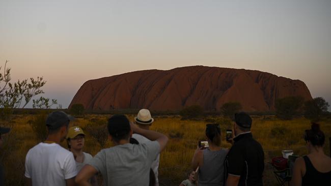 Tourists<s1> take in the awe-inspiring scene of Uluru at sunset at Uluru-Kata Tjuta National Park</s1> <source>. Picture: AAP</source>