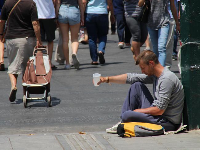 Desperate for money ... As well as huge queues outside roller shuttered banks are beggars with cups in hand, a sight many Greeks said was unheard of even a few months ago. Picture: Charles Miranda