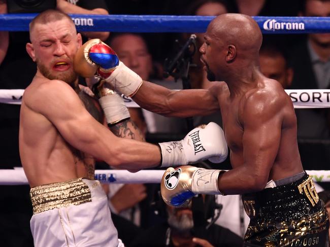 Floyd Mayweather Jr. punches Conor McGregor in their super welterweight bout.
