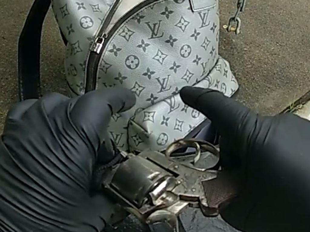 Police examine the gun allegedly found in the car. Picture: QPS
