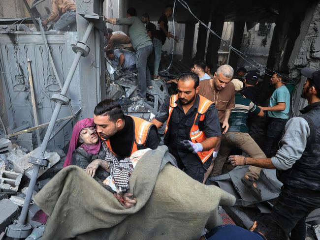 Palestinians carry an injured person as rescuers search the rubble of a building for survivors following Israeli bombardment in Khan Yunis in the southern Gaza Strip. Picture: AFP