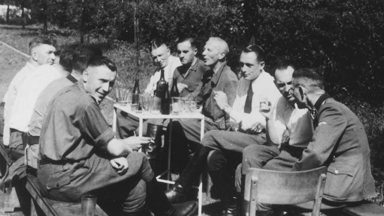 Caption SS officers, including several SS physicians, sit around a table drinking. Picture: United States Holocaust Memorial Museum