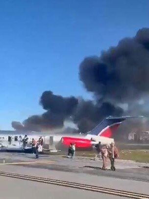 Passengers walk away from the burning plane. Picture: Supplied