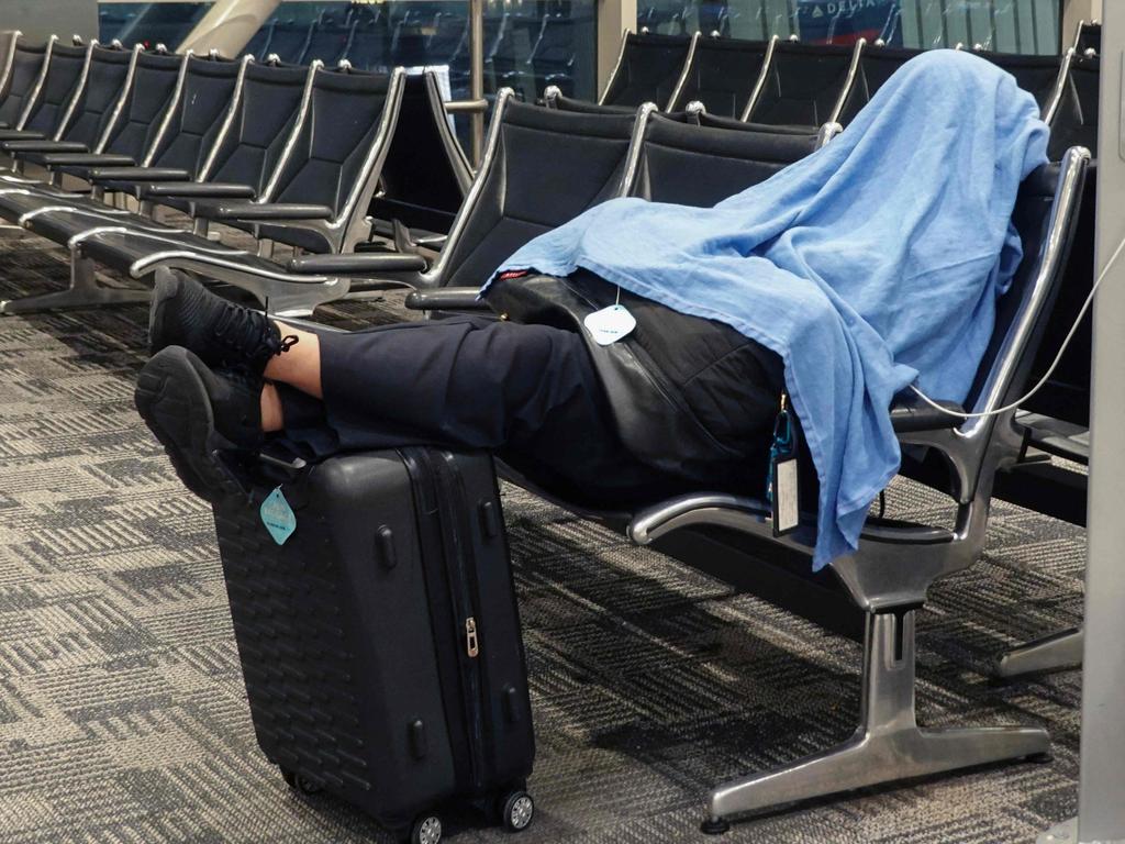 Passengers sleep where stranded as the world continues to be affected by a global technology outage attributed to a software update administered by CrowdStrike, a cybersecurity firm. Picture: AFP