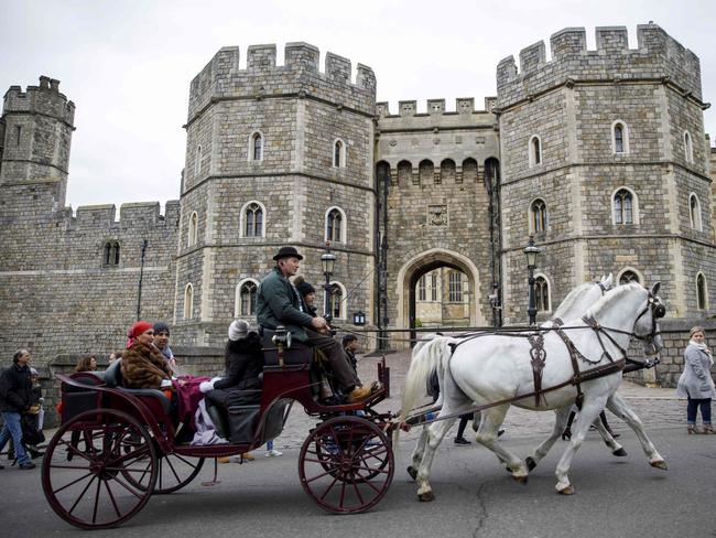 Tourists ride in a horse-drawn carriage past the main entrance of Windsor Castle, where Prince Harry and Meghan will marry in May. Picture: AFP