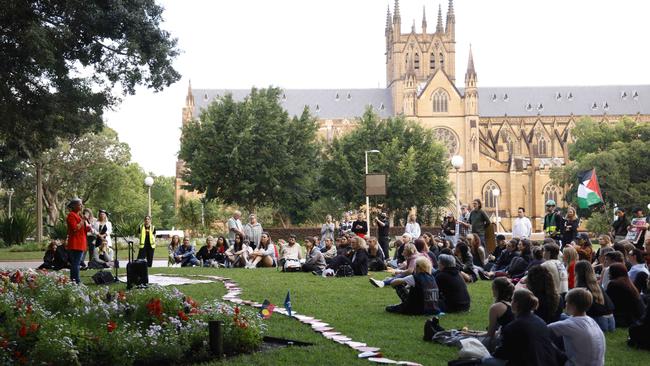 Marchers lay flowers and fake candles in the park. Picture: NewsWire / Damian Shaw