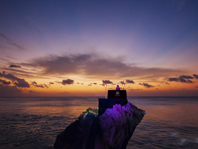 A DJ perched on the rock while the sun goes down. Perfection.