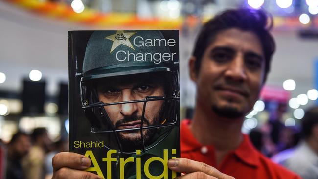 Afridi with his book, which lifts the lid on his dramatic walk out on the team.