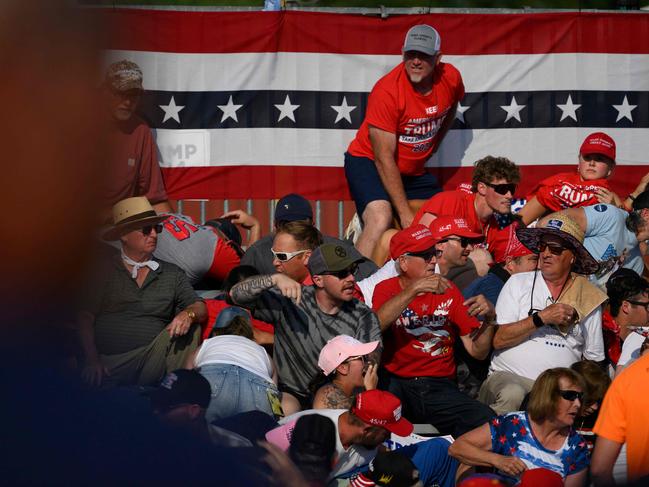 Attendees duck from gunfire during the campaign rally. Picture: Getty Images