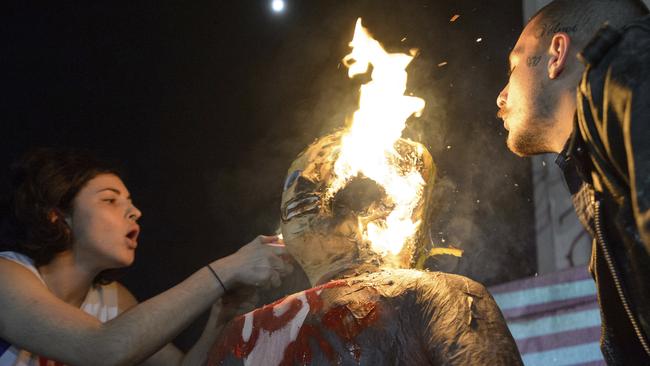 Two protesters set fire to an effigy of Donald Trump, during an anti-Trump protest in New Orleans. Picture: Matthew Hinton