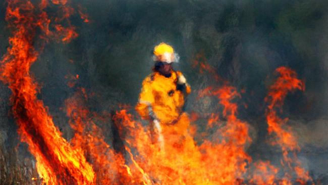 A firefighter works to contain a blaze. Photo: Rob Williams