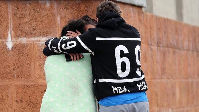 People are consoling each other outside the house where three people were killed in Ellenbrook, Perth, Sunday, July 15, 2018. Picture: AAP/Trevor Collens.