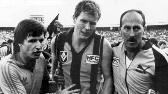 After Jim Stynes ran through the mark, Gary Buckenara received a 15m penalty and slotted the matchwinner after the siren. Here, the Hawks forward is helped off the ground by trainers.