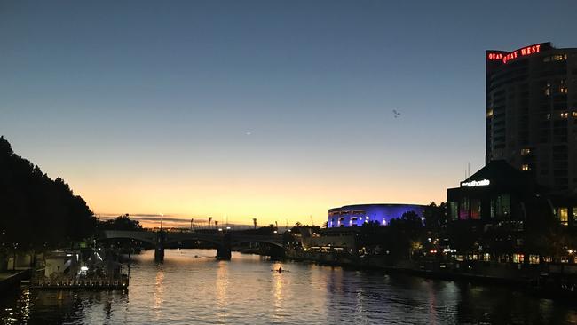 The sun peeking out from behind the Yarra River.