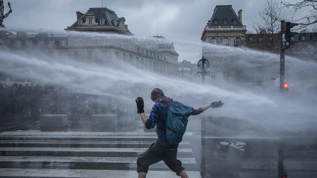 A protestor is hit by water cannon on the Place de la Republique in Paris on Saturday; city prosecutors say 26 people were detained. Picture: Getty Images