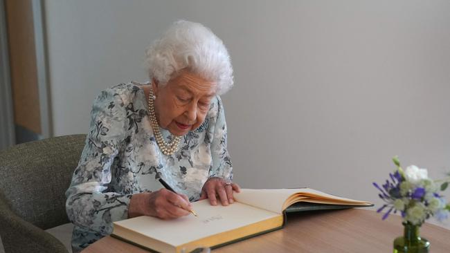 Britain's Queen Elizabeth II signs a guest book during a visit to officially open the new building of Thames Hospice in Maidenhead, Berkshire, on July 15, 2022. (Photo by Kirsty O'Connor / POOL / AFP)