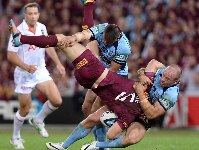 Brent Tate of the Maroons is picked up in the tackle by Josh Reynolds and Beau Scott during the Origin opener. Photo: Bradley Kanaris/Getty Images