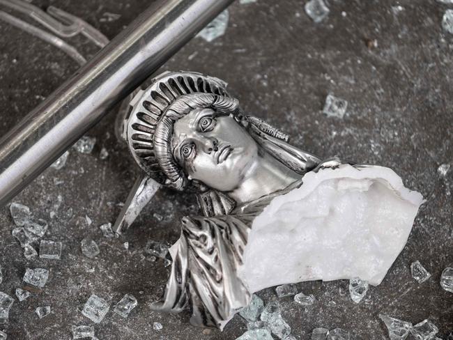 A broken Statue of Liberty figure outside a looted souvenir shop in Manhattan. Picture: AFP