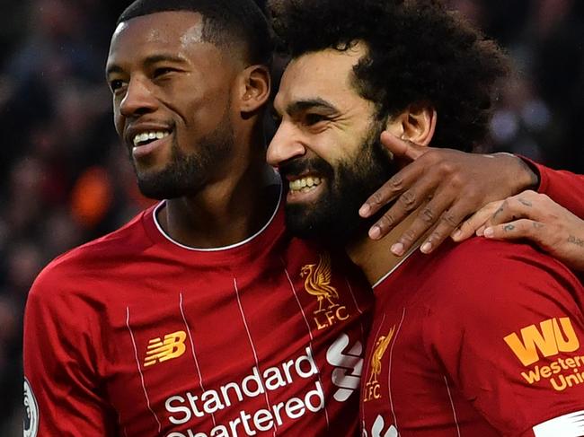 Liverpool's Egyptian midfielder Mohamed Salah (C) celebrates with teammates after scoring his team's third goal during the English Premier League football match between Liverpool and Southampton at Anfield in Liverpool, north west England on February 1, 2020. (Photo by Paul ELLIS / AFP) / RESTRICTED TO EDITORIAL USE. No use with unauthorized audio, video, data, fixture lists, club/league logos or 'live' services. Online in-match use limited to 120 images. An additional 40 images may be used in extra time. No video emulation. Social media in-match use limited to 120 images. An additional 40 images may be used in extra time. No use in betting publications, games or single club/league/player publications. /