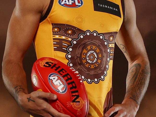 WARNING WARNING CONTACT HERAL SUN BEFORE USE WARNING WARNING  MELBOURNE. 19/05/2022..   Hawthorn Indigenous Players Jarman Impey, Chad Wingard and Tyler Brockman pose at Waverly Park this morning in the clubs indigenous rounds jumper and holding Sherrins designed by Auntie Jennifer Louise (Lulu) Coombes  which will be used in all games over the Sir Doug Nicholls rounds  . Photo by Michael Klein