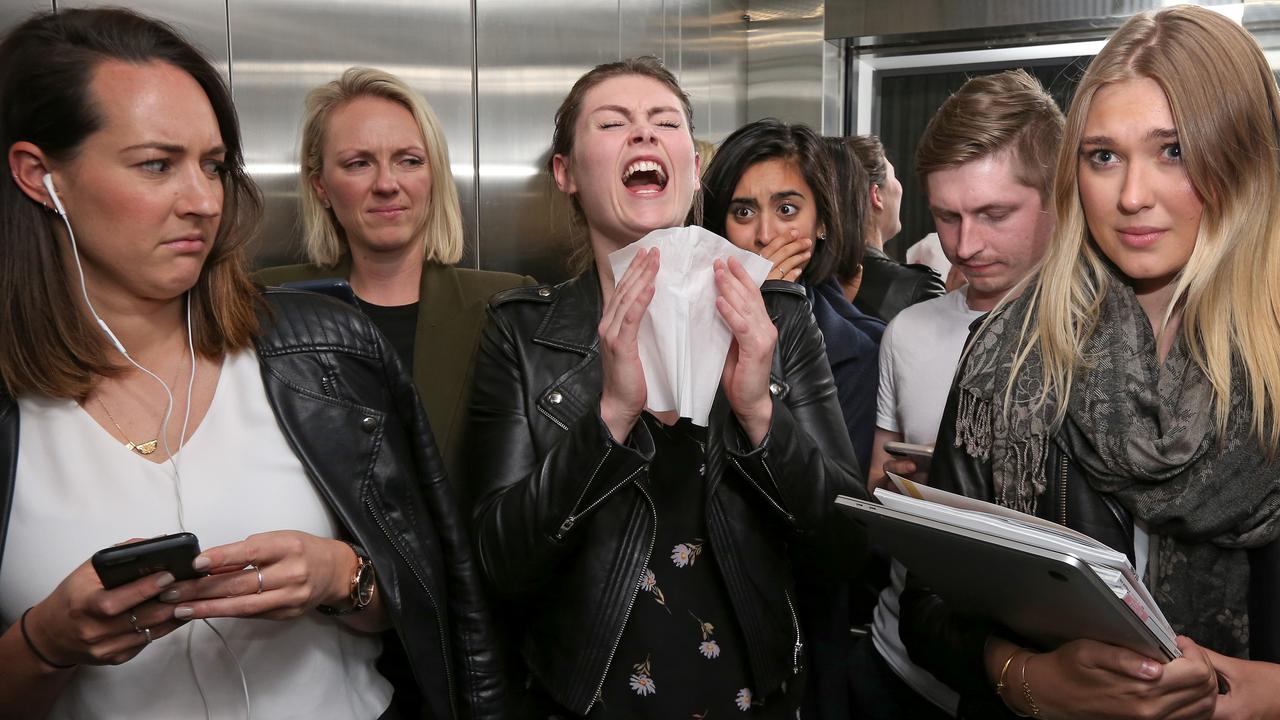 Tash McGarrell sneezes in the lift at work. Story on flu spreading in confined spaces. Picture: Toby Zerna