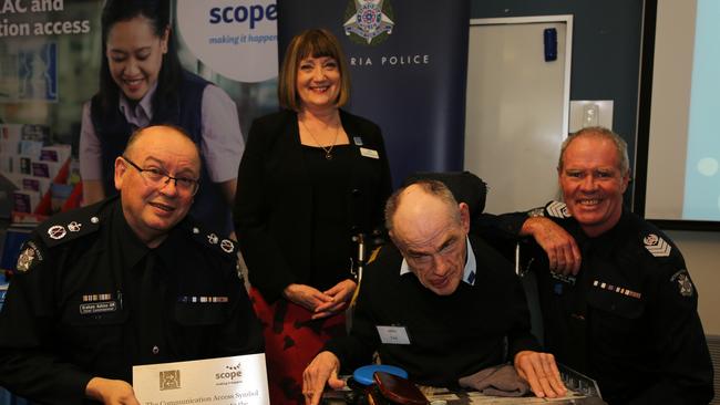 Chief Commissioner Graham Ashton, Scope chief executive Jenny Fitzgerald, John, and Box Hill police station Senior Sergeant Ron Sinclair at the award ceremony.