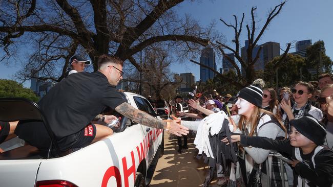 Collingwood player Jamie Elliott high fives fans during the parade. Picture: David Caird